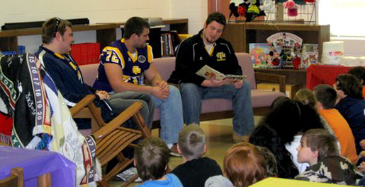 Football players read to students at Cane Creek Elementary